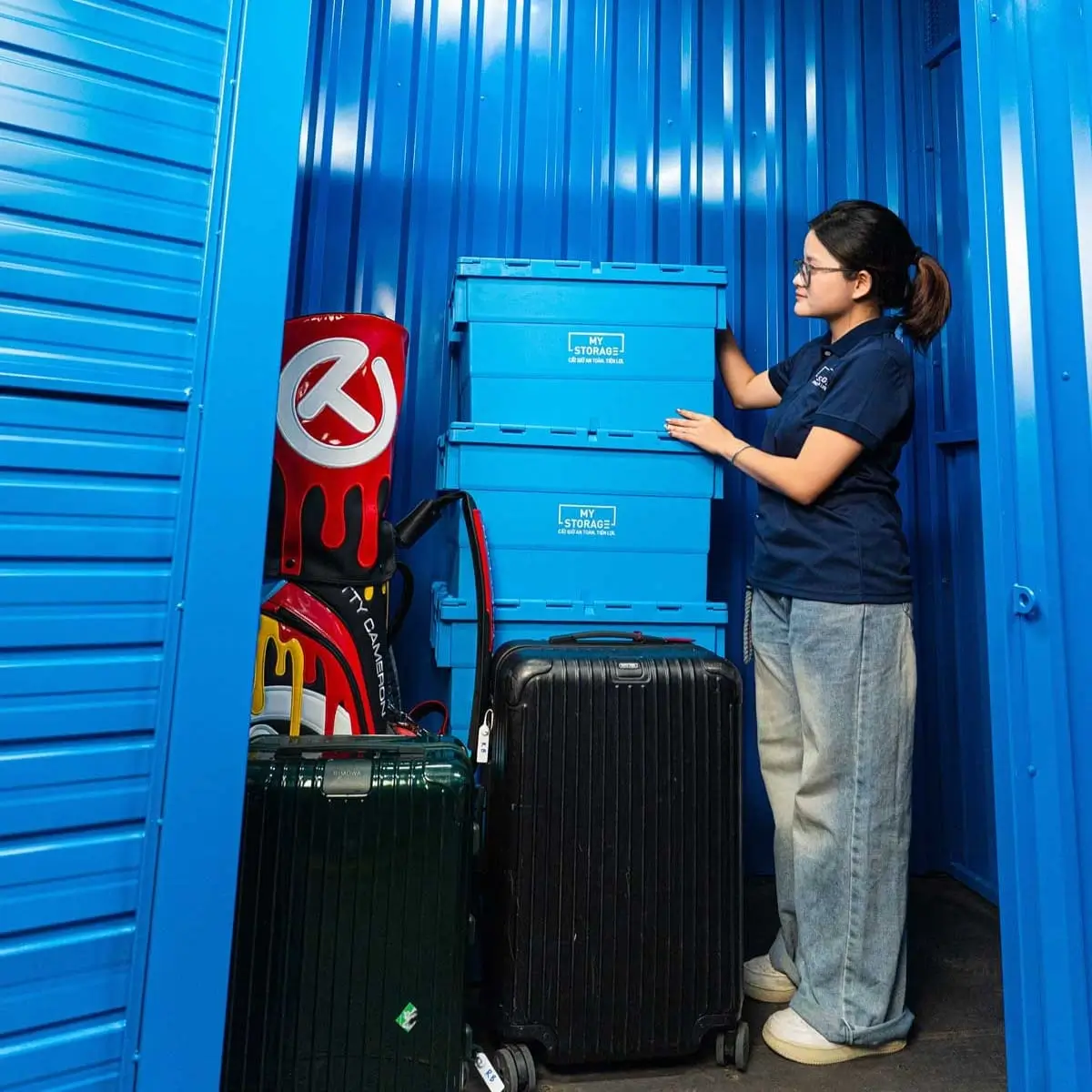 MyStorageのセルフストレージユニットでスーツケースを整理する女性のお客様