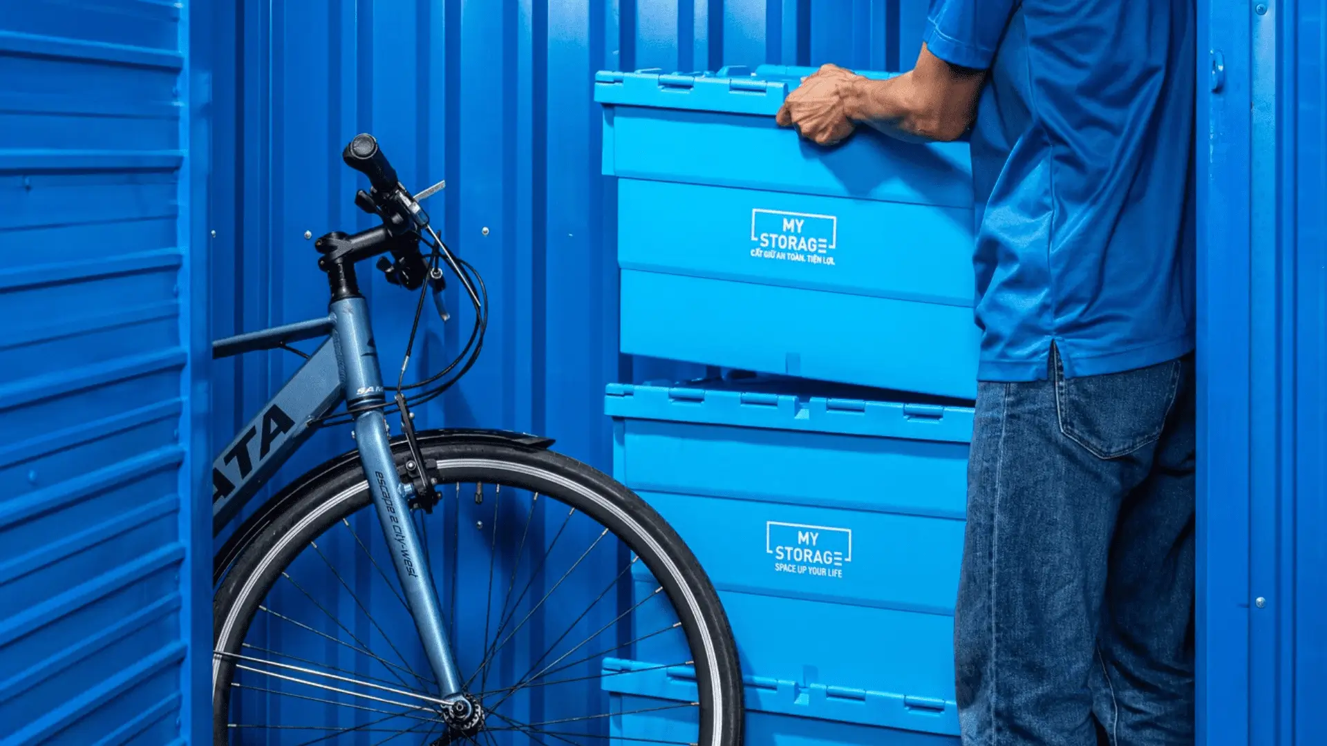 MyStorageの施設で自転車と一緒にいる男性。