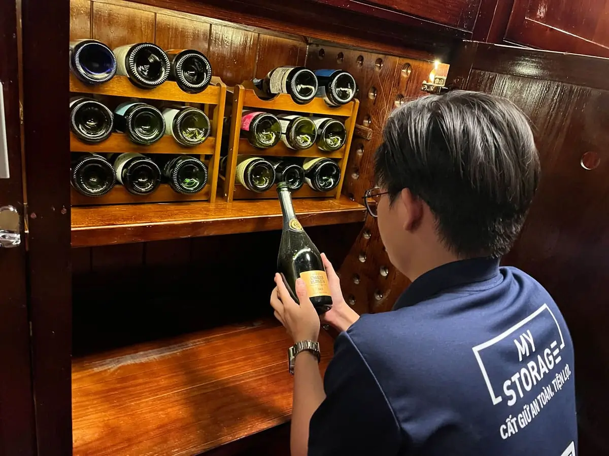 ワイン保管室でワインボトルを手にするMyStorageのスタッフ