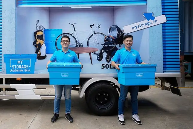 MyStorageの施設で収納ボックスを運ぶ2人の男性